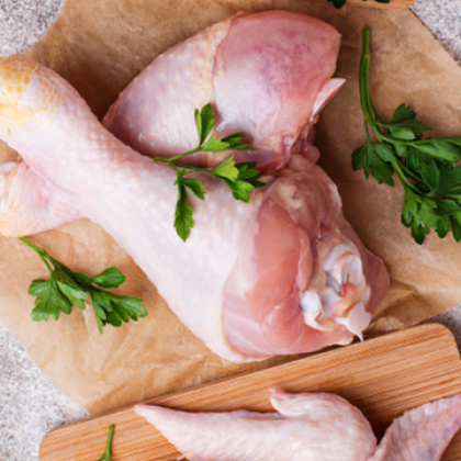 cut chicken tighs on a wooden surface